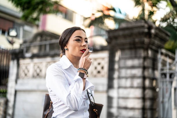 Businesswoman smoking a cigarette outside before a flight in Canada