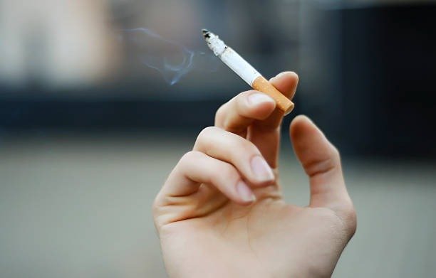 Close up of cigarette in hand representing menthol tobacco purchase