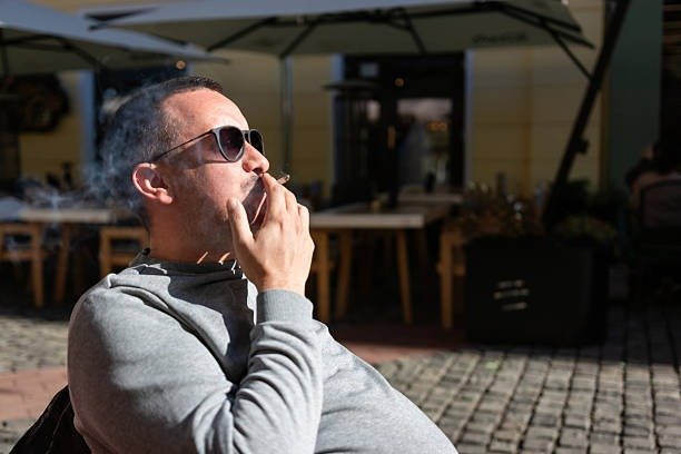 Man smoking a regulated cigarette outdoors in Canada