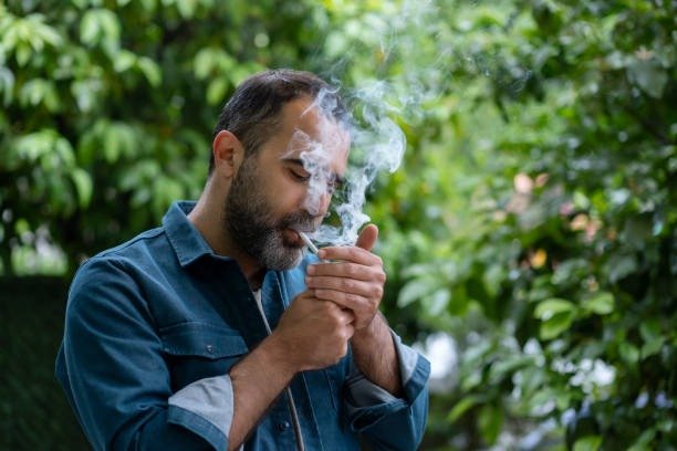 Mature man smoking ultra light cigarette outdoors