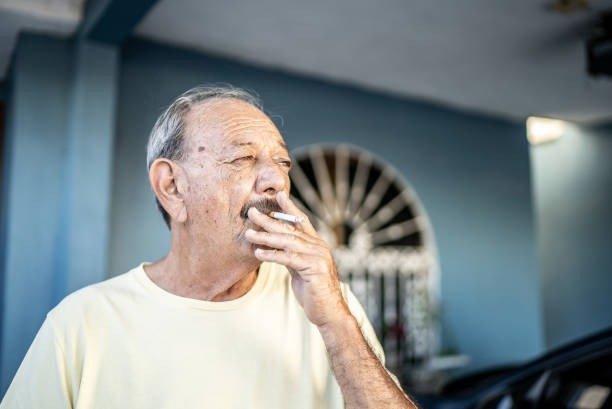 Senior Canadian man smoking a cigarette at home