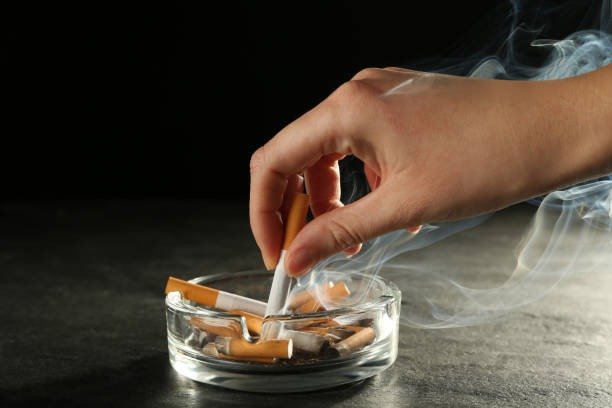 Woman extinguishing a cigarette in an ashtray
